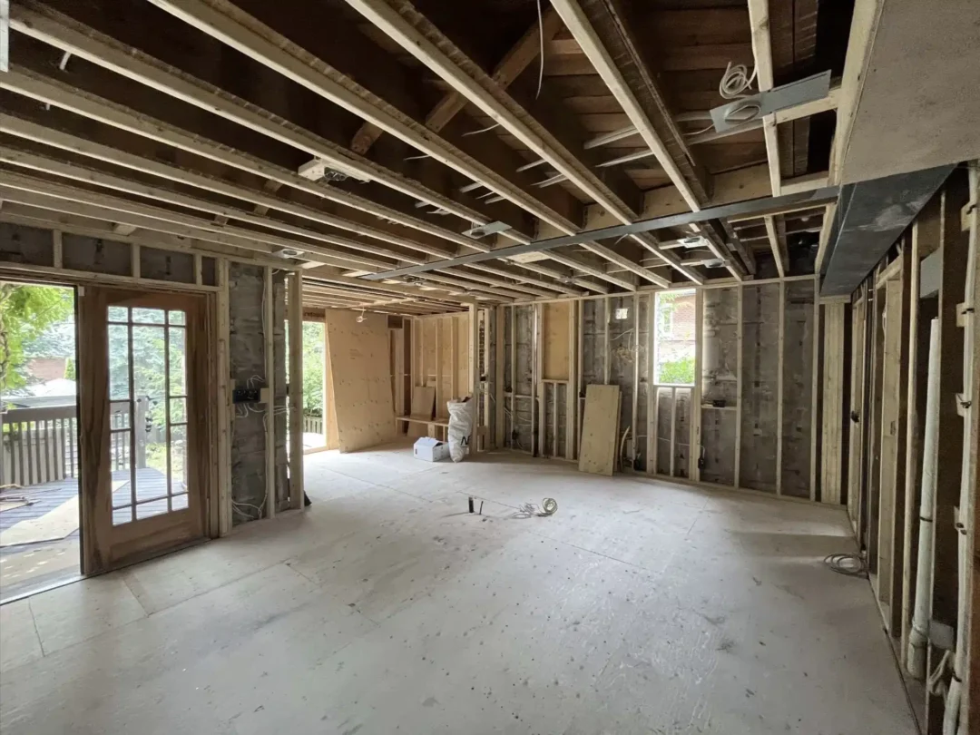 Progress view of a main floor residential remodel demonstrating a wide structural span for a future open concept kitchen and living area layout.